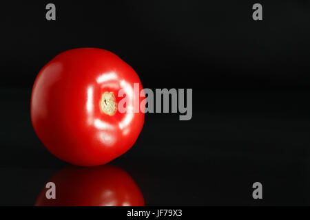 Freschezza ordinaria di pomodoro rosso su sfondo nero con la riflessione Foto Stock