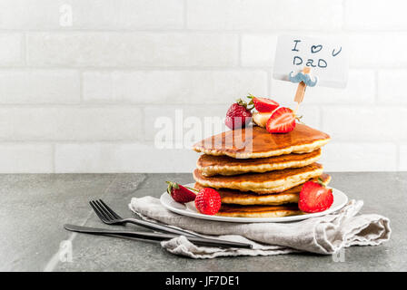 Per celebrare la festa del papà. La prima colazione. L'idea per il delizioso e abbondante colazione vacanze: Frittelle con burro, acero e sciroppo di fragole fresche, wi Foto Stock