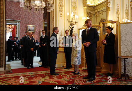 La Regina Elisabetta II e il Principe Harry accolgono gli ospiti durante un ricevimento prima della cerimonia del Queen's Young Leaders Awards a Buckingham Palace, a Londra. Foto Stock