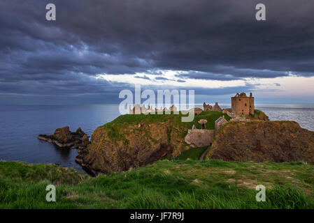 Minacciose nuvole scure sopra il castello di Dunnottar, rovinato fortezza medievale vicino a Stonehaven a picco sul mare lungo la costa del Mare del Nord, Aberdeenshire, Scozia Foto Stock