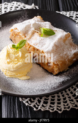 Pane appena sfornato lo strudel di mele con gelato alla vaniglia e menta closeup su di una piastra verticale. Foto Stock