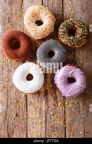 Ciambelle multicolori con riempimenti di close-up sul tavolo. vista verticale da sopra Foto Stock