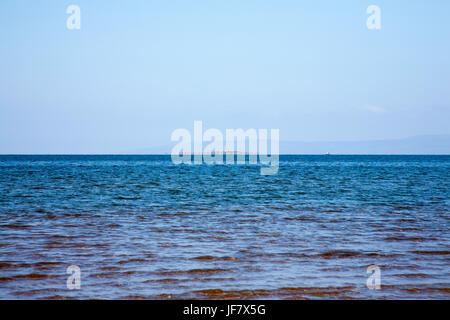 Guardando verso la Signora Isle e Lady Isle Lighthouse l'isola di Arran sfondo dalla spiaggia a Troon in una luminosa mattina di primavera Ayrshire in Scozia Foto Stock