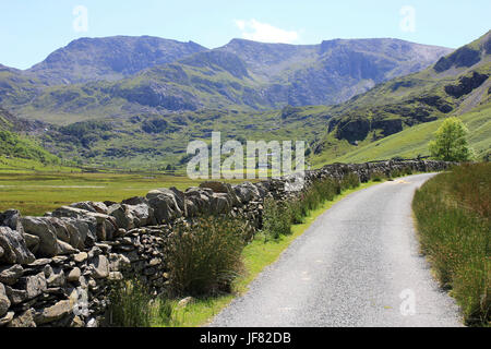 Strada che costeggia il Nant Francon Valley, Snowdonia, Galles con picchi di Glyder Fawr e Glyder Fach come sfondo Foto Stock