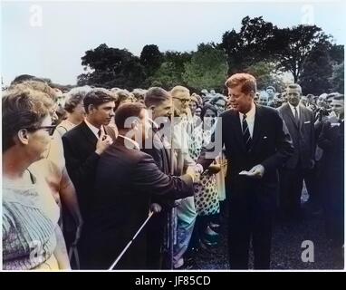 Il presidente John F. Kennedy saluta i volontari con il Corpo di pace sul south lawn alla Casa Bianca di Washington, D.C, 9 agosto 1962. Immagine cortesia archivi nazionali. Nota: l'immagine è stato colorizzato digitalmente usando un processo moderno. I colori possono non essere periodo-precisa. Foto Stock