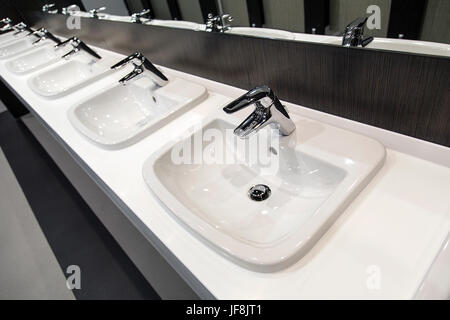 Bagno pubblico - Fila di lavandini e rubinetti Foto Stock