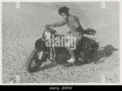 Un momento nel tempo catturato durante un tour in moto, mostrando un uomo che posa orgogliosamente sulla moto di Arthur Staal, simboleggiando la libertà e lo spirito avventuroso dei primi anni del XX secolo. Foto Stock