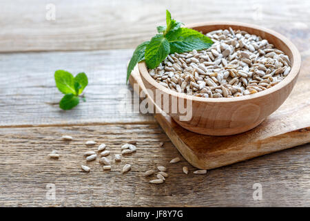 Sbucciate i semi di girasole in una ciotola di legno. Foto Stock