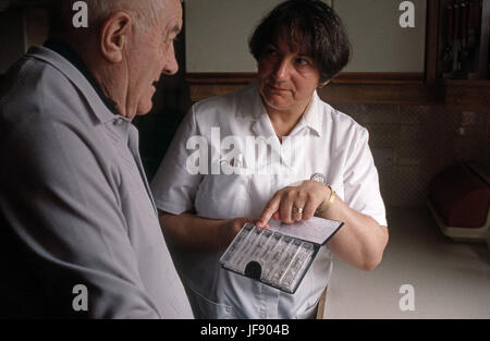 Visitatore di salute assistere anziani uomo con la sua gestione delle cure mediche Foto Stock