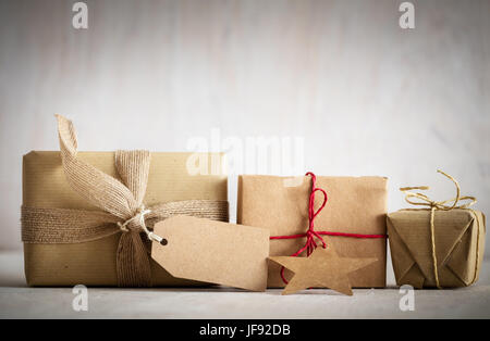 Rustico doni retrò, presenti caselle con tag per i vostri desideri. Il tempo di Natale, vintage umore. Fatte a mano carta eco wrap. Foto Stock