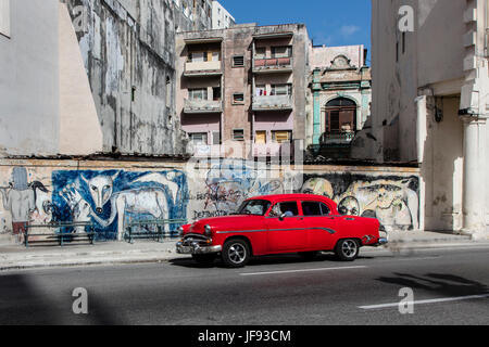 Un auto classica e murale di strada lungo il Paseo de MARTI conosciuta anche come il Museo del Prado - Havana, Cuba Foto Stock