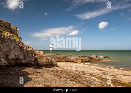 Bellissimo paesaggio marino raffigurante Penmon Faro e il circostante caratteristiche costiere, (Trwyn Du, persico Rock, Ynys Seiriol, Puffin Island) su una giornata d'estate. Foto Stock