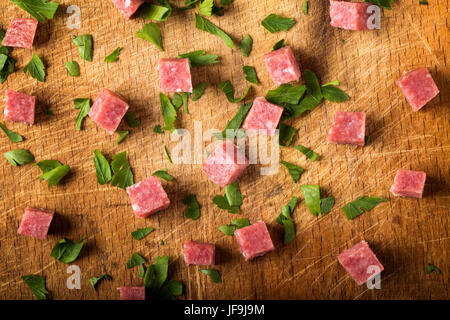 Cubetti di affumicato salame italiano sul tagliere di legno Foto Stock