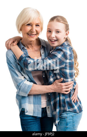 Ritratto di felice la nonna e la nipote abbracciando isolato su bianco in studio Foto Stock