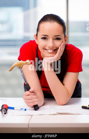 Giovane donna in tute le riparazioni facendo Foto Stock