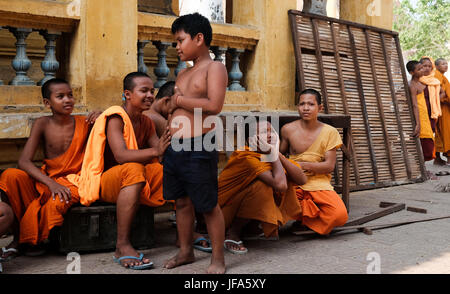 I monaci buddisti impegnati in varie attività nel e intorno al Palazzo Reale di Phnom Penh, Cambogia Foto Stock