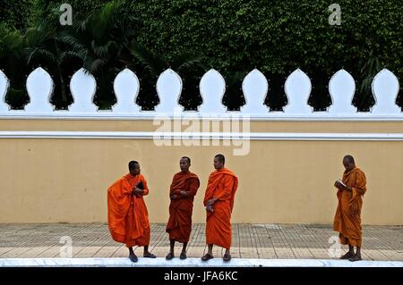 I monaci buddisti impegnati in varie attività nel e intorno al Palazzo Reale di Phnom Penh, Cambogia Foto Stock