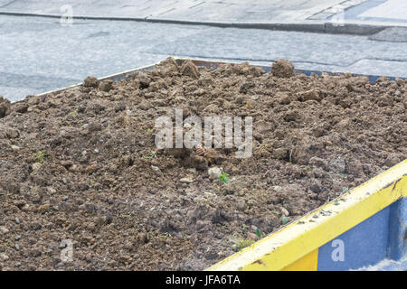 Contenitori blu piena di macerie e la messa a terra Foto Stock