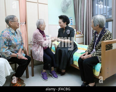 Hong Kong, Cina. Il 30 giugno, 2017. Peng Liyuan (2R), la moglie del Presidente cinese Xi Jinping, colloqui con i cittadini anziani a Tung Wah gruppo di ospedali Jockey Club Sunshine complesso per gli anziani di Hong Kong, Cina del Sud, 30 giugno 2017. Peng ha visitato il centro anziani di venerdì, accompagnato da Regina Leung, moglie di capo esecutivo della regione amministrativa speciale di Hong Kong Leung Chun-ying. Credito: Wang Ye/Xinhua/Alamy Live News Foto Stock