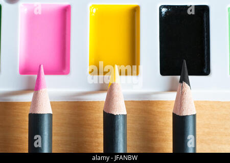 Chiudere fino a matita di punte rivolte verso l'alto per la corrispondenza dei colori su una tavolozza di vernice per illustrare la corrispondenza dei colori o picking o mixed media. Foto Stock