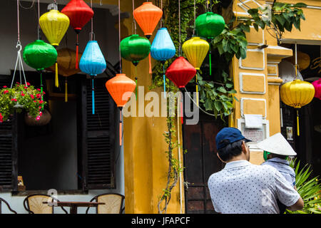 Turisti cinesi e il suo giovane figlio a piedi tra lanterne tradizionali in Hoi An, Vietnam Foto Stock