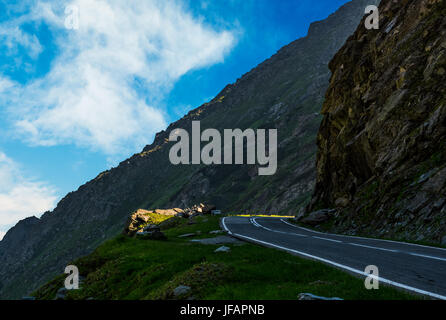 Strada asfaltata sul bordo di una collina. modo pericoloso in montagna Foto Stock