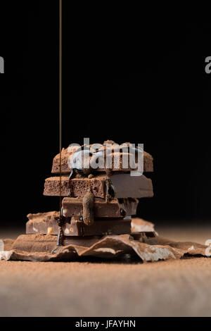 Piramide di cioccolato spolverati con sciroppo sul tavolo di legno a nero lo sfondo vuoto Foto Stock