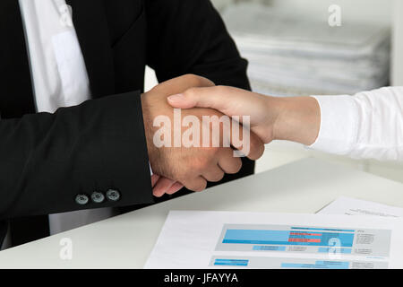 Imprenditore e imprenditrice stringono le mani, finitura fino a una riunione. Vista ravvicinata. Foto Stock