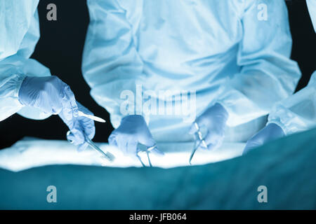 Il team medico di eseguire l'operazione. Gruppo di chirurgo a lavorare in sala operatoria. Mani vista da vicino Foto Stock