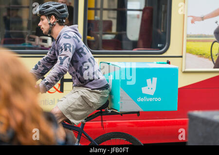 Consegna Deliveroo uomo su una bicicletta in Brighton, East Sussex, Inghilterra, Regno Unito. Foto Stock