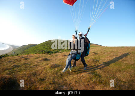 Parapendio in tandem di decollare sopra la spiaggia. Foto Stock