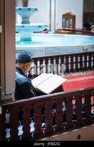 Bursa, Turchia - Febbraio 04, 2017: l uomo è la lettura del Corano nella grande moschea (Ulu Cami) che è la più grande moschea di Bursa. Foto Stock