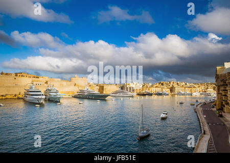 Senglea, Malta - Panoramico vew di yacht e barche a vela di ormeggio a Senglea marina in Canal Grande di Malta su un luminoso giorno di estate merita blue sk Foto Stock