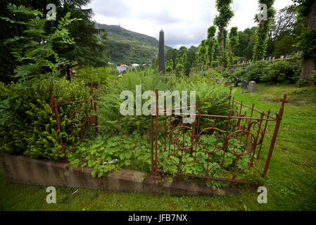 Unkempt sepoltura plot Møllendal cimitero di Bergen, Norvegia, con lo sfondo della città di sconfinare nella distanza. Foto Stock