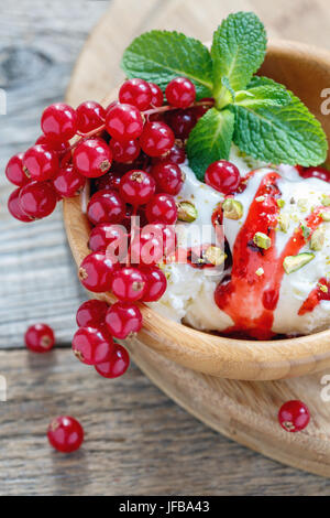 Gelato alla vaniglia con ribes rosso e pistacchi. Foto Stock