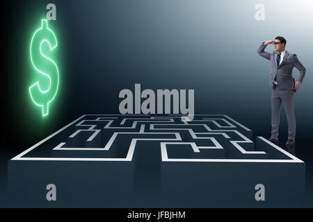 Uomo che cerca di raggiungere dollari attraverso il labirinto Foto Stock