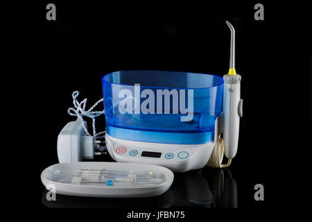 Irrigatore orale con una varietà di suggerimenti su sfondo nero. Foto Stock