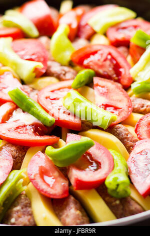 Le polpette di carne al forno guarnito con pomodori e peperoni e patate Foto Stock