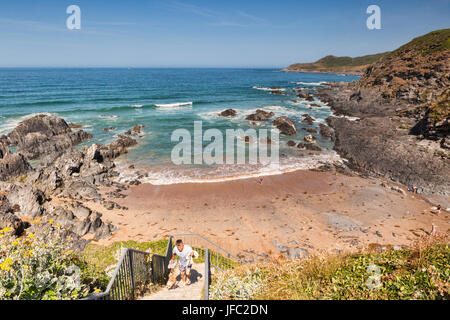 17 Giugno 2017: Combesgate Beach, Woolacombe, North Devon, Inghilterra, Regno Unito - un uomo e il suo dof lasciare la spiaggia. Foto Stock