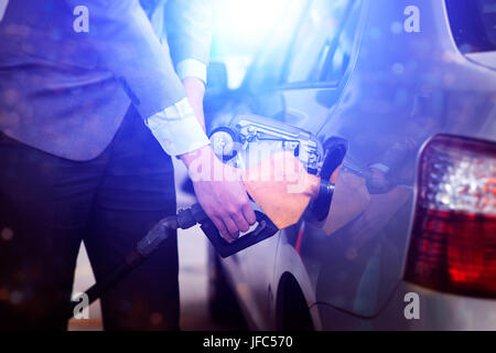 Il rifornimento di gas. Close up uomo benzina di pompaggio in auto alla stazione di benzina. Foto Stock