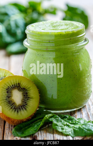 Un sano frullato verde in barattolo di spinaci e kiwi vicino. Foto Stock