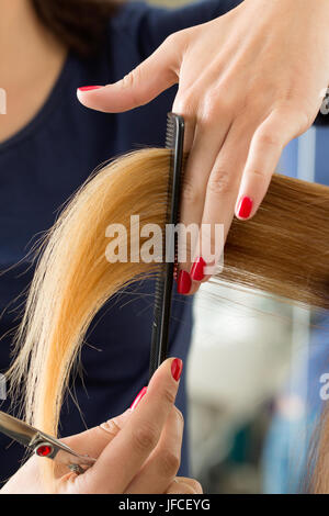 Vista ravvicinata del parrucchiere femmina mani il taglio di capelli suggerimenti. Restauro di cheratina, capelli sani, capelli più recenti tendenze della moda, cambiando taglio di capelli, sh Foto Stock