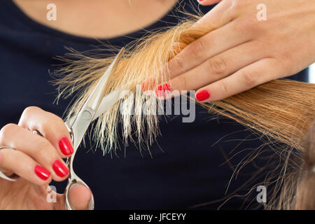 Vista ravvicinata del parrucchiere femmina mani il taglio di capelli suggerimenti. Restauro di cheratina, capelli sani, capelli più recenti tendenze della moda, cambiando taglio di capelli, sh Foto Stock