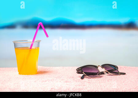 Paradise Vacanze con sfondo giallo cocktail su occhiali da sole sulla spiaggia. Perfetto per l'estate di vendita e di offrire promozione della campagna. Foto Stock