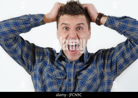 Emotional Ritratto di giovane arrabbiato urlando uomo tirando i suoi capelli. Emozioni umane espressione facciale sensazione Foto Stock