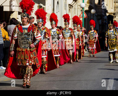 Abitanti di Zejtun / Malta aveva loro tradizionale processione del Venerdì santo di fronte alla loro chiesa, alcuni di loro vestiti come legionari romani Foto Stock