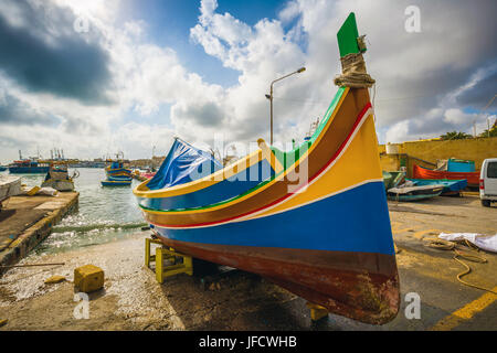 Marsaxlokk, Malta - Tradizionale Luzzu fisherboat presso il famoso mercato di Marsaxlokk su una soleggiata giornata estiva Foto Stock
