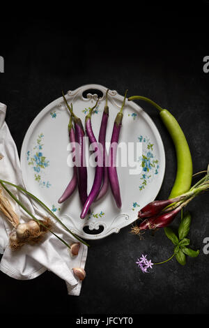 Piastra con siciliana di prodotti agricoli: melanzane Perlina varietà, aglio, molla cipolle rosse e un particolare squash chiamato cucuzza o zucchetta ser Foto Stock