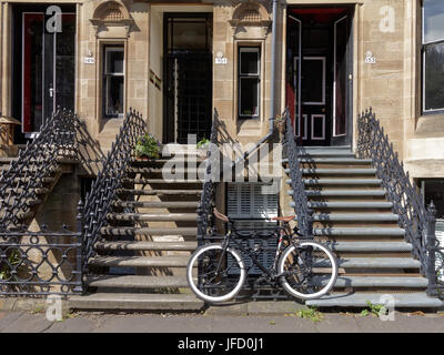 Glasgow tenements sfondo vita bionda ingressi di arenaria sistemazione con grafico bike a fondo delle scale Foto Stock