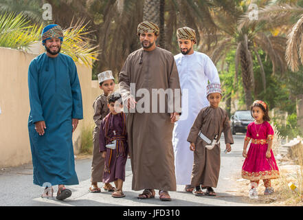 Nizwa, Oman - 26 Giugno 2017: famiglia in abbigliamento tradizionale a un giocattolo sul mercato un giorno di Eid Al Fitr, festa in occasione della fine del mese sacro del Ramadan Foto Stock